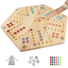 a wooden board game set with several pieces and dices on the board, including one person's hand