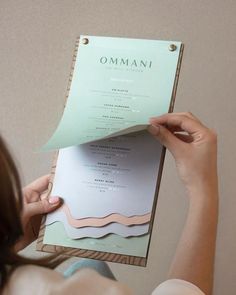 a woman holding up a piece of paper with the word ommani on it