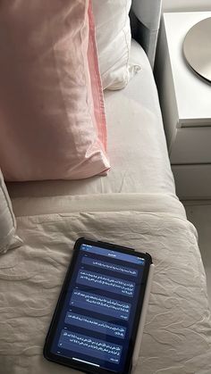 an electronic device sitting on top of a bed next to pillows