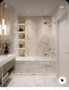 a bathroom with marble walls and flooring is shown in this image, there are lights on either side of the bathtub