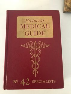 a red medical book sitting on top of a table