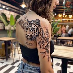 a woman with a tiger tattoo on her shoulder