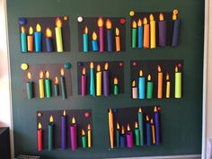 many different colored candles are arranged on the wall