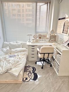 a bedroom with a bed, desk and computer on it in front of a window