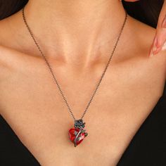 Wrap yourself in dark romance with the captivating Heart Rose Necklace. This striking piece features a vibrant blood-red zircon heart, delicately entwined with a black rose and vine detailing. Crafted with a sleek, durable metal finish, this necklace is designed for those who embrace a bold, gothic aesthetic. Whether you're adding a dramatic touch to your outfit or expressing your unique style, the Heart Rose Necklace is perfect for making a statement that lasts. Materials: Plated Brass, Zircon Red Heart Necklace, Neo Gothic, Grunge Jewelry, Gothic Rose, Red Love Heart, Y2k Jewelry, Rose Heart, Heart Rose, Rosé Heart