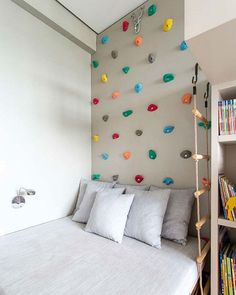 a bedroom with a bed, bookshelf and climbing wall in the corner area