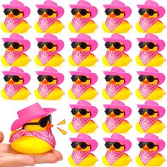 a hand holding a rubber duck with sunglasses on it's head