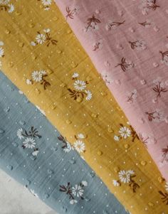 four different colors of fabric with flowers and dots on the bottom one is blue, yellow, pink, and white