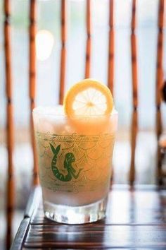 an orange slice is sitting on the rim of a glass with a drink in it