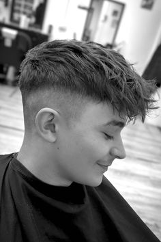 This on-trend hairstyle has a big, messy top that gives it a current and edgy look. The sides are shaved very close while fading up to the shorter hair on top. This creates a stark difference between the longer hair on top and the skin on the sides. This adaptable style is ideal for people looking for a fashionable cut that can be - Click to see more of Longer Top, Cool Cuts: 32 Stylish Boy Haircuts to Try and follow us for more hairstyle ideas. // Photo Credit: Instagram @boyshairstyle0 Haircuts Teenage Boys, Popular Teenage Boys Haircuts, Boys Hair Short Sides Long Top, Textured Fringe Boys Haircut, Fringe Boys Haircut, Messy Boys Hair, Teenage Haircuts Boys, Short Back And Sides Mens, Boys Hair Cut Long On Top Short On Sides