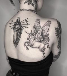 the back of a woman's shoulder with tattoos on it and an angel riding a horse