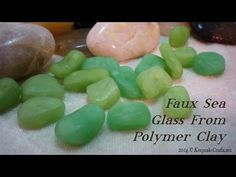 some green and yellow gummy bears are on a white table cloth next to rocks