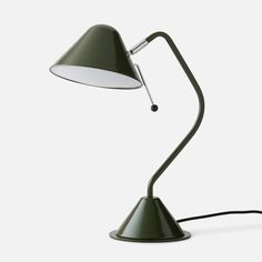 a green desk lamp with a white light on it's side and a black cord