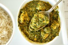 a spoon in a bowl filled with rice and spinach sauce next to another bowl full of rice