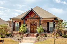 a brick house with two front porches and steps leading up to the entry door