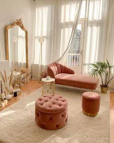 a living room filled with furniture and a large mirror on the wall above it's windows