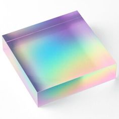 a box that is sitting on the ground next to a white surface with an iridescent pattern