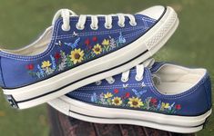 two blue shoes with flowers painted on them