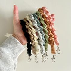 a hand holding several different colored crochet key chains