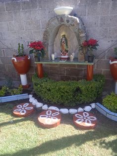 an outdoor garden with flowers and rocks in the center, surrounded by potted plants