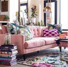 a living room filled with furniture and lots of books on top of a rug next to a window