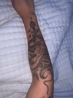 a person laying in bed with a tattoo on their arm