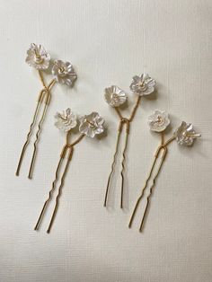 Hair pins with beautiful handmade flowers and beads.  Sold as pack of 4. ITEM SPECIFICATIONS ✨ Package: Pack of 4 pin. ✨ Color: Gold ✨ Material: Clay, white beads and crystal. 💛 Due to differences in light color and display in the photo, the actual item may vary slightly. Each of our products is measured by hand. There may be some differences in measurements.  PROCESSING AND SHIPPING ✨ Your order will be 1-5 business days. ✨ Please check out our shop In case of questions about the product or if Floral Hair Pins Wedding, Korean Wedding Hair, Flower Wedding Hair, Wedding Hair Pin, Hair Pins Wedding, Wedding Hair Jewelry, Floral Hair Pins, Crystal Hair Pins, Wedding Hair Flowers