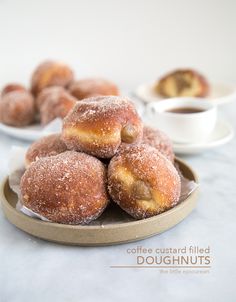 sugar covered doughnuts on a plate with coffee