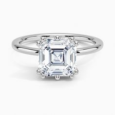 an emerald - cut diamond ring with three clawed shans, set in 18k white gold