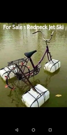 a bicycle that is in some water with two bags attached to the front tire and seat