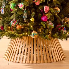 a christmas tree with ornaments in a wooden basket