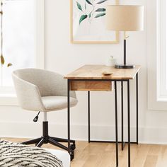 a desk with a lamp and chair in front of a painting on the wall above it