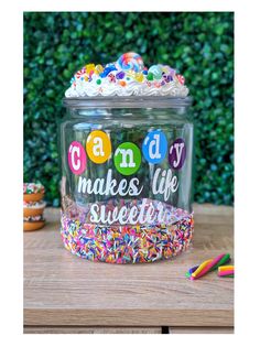 a glass jar filled with lots of sprinkles on top of a wooden table