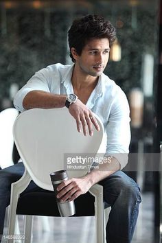 a man sitting on top of a white chair