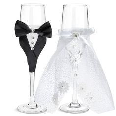 two wine glasses decorated with black and white bows, one in the shape of a tuxedo