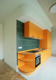 an orange and green kitchen with wooden floors