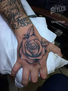 a man's hand with a rose tattoo on it