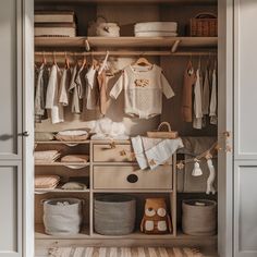 an organized closet with clothes and other items on the shelves, including baby's clothing