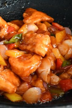 chicken and peppers cooking in a wok on the stove