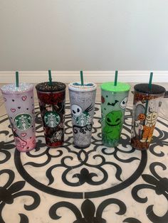 six starbucks cups are lined up on the floor