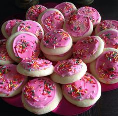 pink frosted cookies with sprinkles on a plate