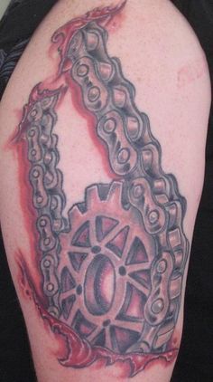 a man with a tattoo on his arm that has chains attached to the back of it