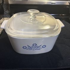 a glass covered casserole sitting on top of a black tablecloth next to an oven