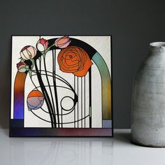 a vase sitting next to a painting on top of a table