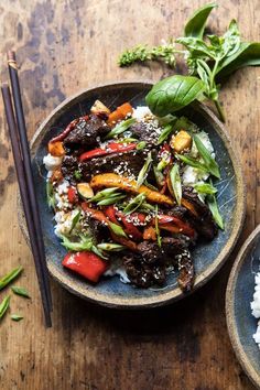 a plate with rice and vegetables on it next to chopsticks