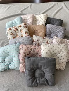 a bunch of pillows that are laying on a bed