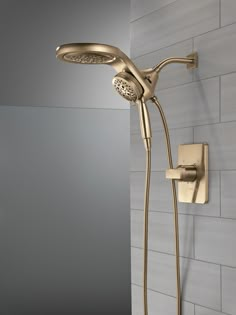 a gold shower head and hand shower in a bathroom