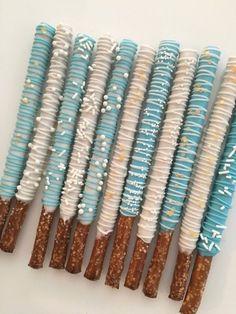 six blue and white decorated pretzels are lined up in a row with sprinkles on them