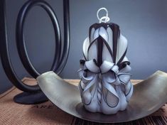 a white and black vase sitting on top of a metal plate