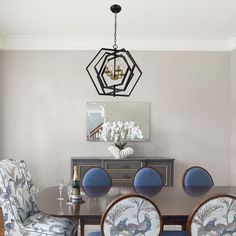 a dining room table with blue chairs and a chandelier hanging from the ceiling